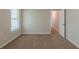 Light-filled bedroom with soft carpeting and an open doorway to the hallway at 6205 Leverett Dr, Lithonia, GA 30038