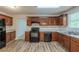 Well-equipped kitchen featuring dark wood cabinets, modern appliances, and durable laminate flooring at 6205 Leverett Dr, Lithonia, GA 30038