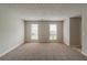Bright living room featuring plush carpet and lots of natural light from the windows at 6205 Leverett Dr, Lithonia, GA 30038