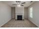 Comfortable living room featuring plush carpet, a ceiling fan, and a classic fireplace at 6205 Leverett Dr, Lithonia, GA 30038