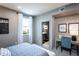 This bedroom is bright and airy with a textured blue accent wall and a view to the outside at 7630 Homer Dr, Cumming, GA 30028