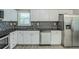 Modern kitchen with white cabinetry, granite counters, stainless steel appliances, and tile backsplash at 1665 Dunbarton Dr, Lithonia, GA 30058