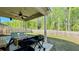 Covered back porch features a ceiling fan, string lights, seating, and a grill, perfect for outdoor entertaining at 1835 Wellston Dr, Lawrenceville, GA 30043