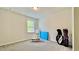 Carpeted bedroom with a window letting in natural light, neutral walls and golf equipment at 1835 Wellston Dr, Lawrenceville, GA 30043
