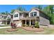 Beautiful home with manicured front lawn, decorative landscaping, and a covered front porch with stately columns at 1835 Wellston Dr, Lawrenceville, GA 30043
