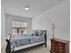 Cozy bedroom featuring a patterned comforter, natural light from the window, and a classic wood dresser at 21 Belmore Manor Dr, Suwanee, GA 30024