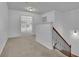 Bright hallway leading to another room, featuring a wooden staircase and plush carpeting, creating an inviting space at 21 Belmore Manor Dr, Suwanee, GA 30024