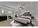 Spacious primary bedroom with a tray ceiling, a ceiling fan, and a cozy sitting area near the bright windows at 21 Belmore Manor Dr, Suwanee, GA 30024