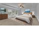 Well-lit main bedroom featuring neutral tones, tray ceiling, large windows, and tasteful décor creating a serene space at 21 Belmore Manor Dr, Suwanee, GA 30024