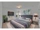 This main bedroom is furnished with a king bed, white walls, and a modern flat screen TV at 21 Belmore Manor Dr, Suwanee, GA 30024