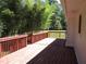 Spacious wooden deck, painted red, with a picturesque view of the lush backyard and mature bamboo at 2107 Briarwood Ct, Snellville, GA 30078
