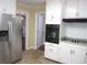 Bright kitchen with stainless steel refrigerator and white cabinets at 2107 Briarwood Ct, Snellville, GA 30078
