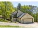 Contemporary home with a black roof and an attached two car garage surrounded by green trees at 2295 Piedmont Ridge Ct, Marietta, GA 30062