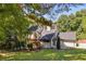 Stylish home with a black roof, wooden stairs, and a spacious front yard with ample green space at 2295 Piedmont Ridge Ct, Marietta, GA 30062