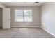 A well-lit bedroom featuring neutral carpet and paint and a large window at 6330 Phillips Pl, Lithonia, GA 30058