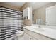 Neat bathroom with a shower and tub behind a striped shower curtain at 1005 Anise Ct, Dacula, GA 30019