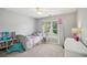 Bright bedroom with a twin bed, soft carpet, a ceiling fan, and large windows offering a pleasant view at 1005 Anise Ct, Dacula, GA 30019
