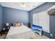 Cozy bedroom featuring a ceiling fan, plush carpet, and a serene blue accent wall at 1005 Anise Ct, Dacula, GA 30019
