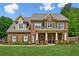 Charming brick home with a welcoming front porch and lush green lawn at 1005 Anise Ct, Dacula, GA 30019
