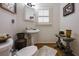 Cozy half-bathroom with pedestal sink, dark wood floors, and a framed mirror at 120 Milano Sw Dr, South Fulton, GA 30331