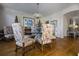 Dining room features a crystal chandelier over a glass table with patterned chairs at 120 Milano Sw Dr, South Fulton, GA 30331