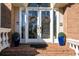 Inviting brick front porch with double doors, adorned with wreaths and blue decorative pots at 120 Milano Sw Dr, South Fulton, GA 30331