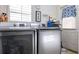 Well-lit laundry room with modern washer and dryer units and ample counter space at 120 Milano Sw Dr, South Fulton, GA 30331