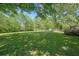 Large backyard with mature trees, green grass and a deck for entertaining at 1214 Marshall Fuller Rd, Dallas, GA 30157