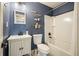 Bathroom with blue walls, tile floors, a single sink vanity and a shower over bath at 1214 Marshall Fuller Rd, Dallas, GA 30157