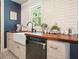 Close up of kitchen sink and dishwasher with wood counters, stylish faucet, and subway tile backsplash at 1214 Marshall Fuller Rd, Dallas, GA 30157