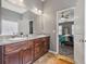 Bathroom featuring dual sinks, a large mirror, and a view into the main bedroom at 256 Bollen Ln, Hiram, GA 30141