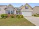 Inviting exterior featuring gray siding, a two-car garage, a well-maintained lawn, and tasteful landscaping at 256 Bollen Ln, Hiram, GA 30141