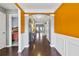 Inviting foyer with dark wood floors, a striking orange accent wall, and elegant white trim at 256 Bollen Ln, Hiram, GA 30141