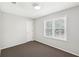A simple bedroom featuring a bright window and plush carpet at 3479 Portsmouth Cir, Lithonia, GA 30038