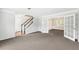 Spacious living room with neutral carpet, staircase, and french doors to another room at 3479 Portsmouth Cir, Lithonia, GA 30038