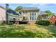 Back exterior with outdoor deck, patio, lawn, and mature landscaping, perfect for relaxing and entertaining at 4862 Tarry Post Ln, Suwanee, GA 30024