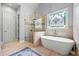 Bathroom featuring walk-in shower, soaking tub, stained-glass window, and neutral color palette at 4862 Tarry Post Ln, Suwanee, GA 30024