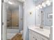 Bright bathroom with a shower/tub combo, white vanity, tile floors and modern lighting at 4862 Tarry Post Ln, Suwanee, GA 30024