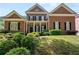 Charming brick home featuring a meticulously landscaped front yard and a welcoming columned entrance at 4862 Tarry Post Ln, Suwanee, GA 30024