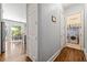 Hallway view with hardwood floors, leading to laundry room and kitchen with stainless steel refrigerator at 4862 Tarry Post Ln, Suwanee, GA 30024