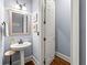Elegant powder room with pedestal sink, wood floors, framed mirror and decorative wall art at 4862 Tarry Post Ln, Suwanee, GA 30024