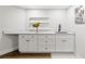 The wet bar area features white cabinets, a counter and sink for entertaining in the home's finished basement at 4862 Tarry Post Ln, Suwanee, GA 30024