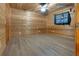 Spacious bedroom with wood-paneled walls, ceiling fan, and light-colored vinyl plank flooring at 5520 Hearn Rd, Ellenwood, GA 30294