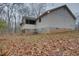 A view of the rear of a home featuring a sunroom and a partially finished basement with access door at 5520 Hearn Rd, Ellenwood, GA 30294