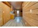 Living room featuring wood-paneled walls, vinyl flooring and a small kitchen area at 5520 Hearn Rd, Ellenwood, GA 30294