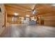Spacious living room with wood walls, hardwood floors, and modern ceiling fan at 5520 Hearn Rd, Ellenwood, GA 30294