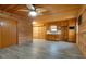 Open-concept living area features wood-paneled walls, vinyl flooring and a small kitchen area at 5520 Hearn Rd, Ellenwood, GA 30294