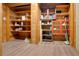 Storage room with wood shelving, wood-paneled walls and light-colored vinyl plank flooring at 5520 Hearn Rd, Ellenwood, GA 30294