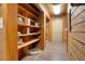 Walk-in storage room with wood shelving, wood-paneled walls, and light-colored vinyl plank flooring at 5520 Hearn Rd, Ellenwood, GA 30294