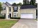 Charming two-story home with a well-manicured lawn and an attached two-car garage at 220 Cameron Ways, Covington, GA 30016